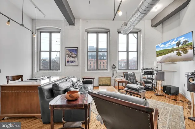 a living room with fireplace furniture and a potted plant