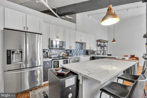 a kitchen with kitchen island a table and chairs