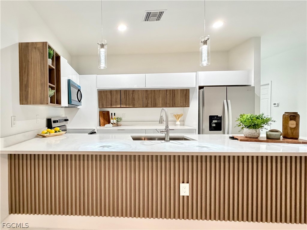 a kitchen with a refrigerator a sink and a wooden floor