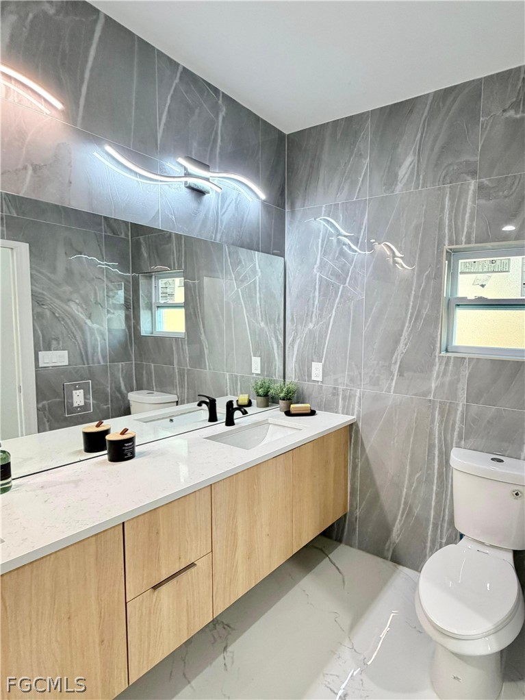 767 Crystal Avenue Lehigh Acres, FL 33974 - Photo 11 of 17 a bathroom with a granite countertop sink toilet and shower