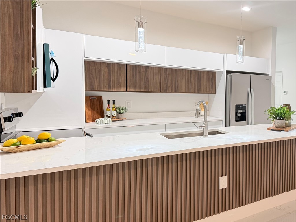 767 Crystal Avenue Lehigh Acres, FL 33974 - Photo 4 of 17 a kitchen with stainless steel appliances a sink dishwasher a refrigerator and a oven with wooden floor