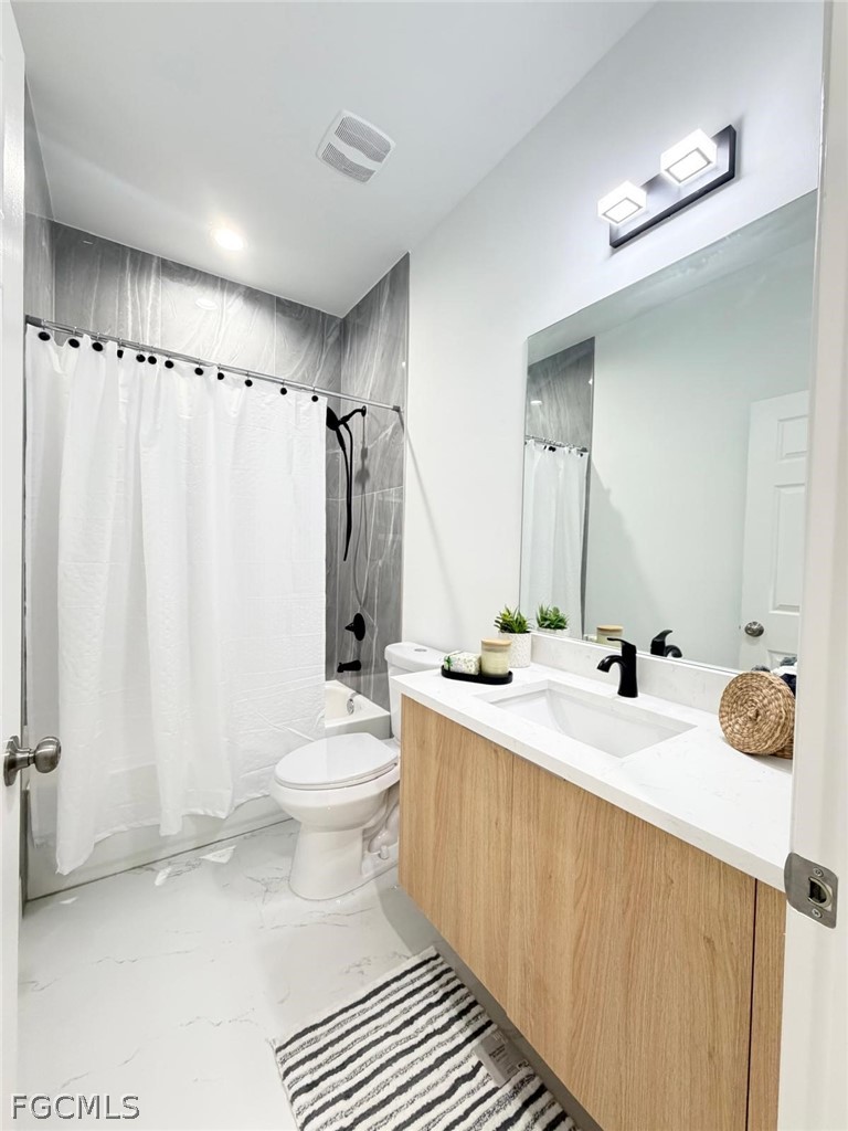 767 Crystal Avenue Lehigh Acres, FL 33974 - Photo 5 of 17 a bathroom with a double vanity sink toilet mirror and shower