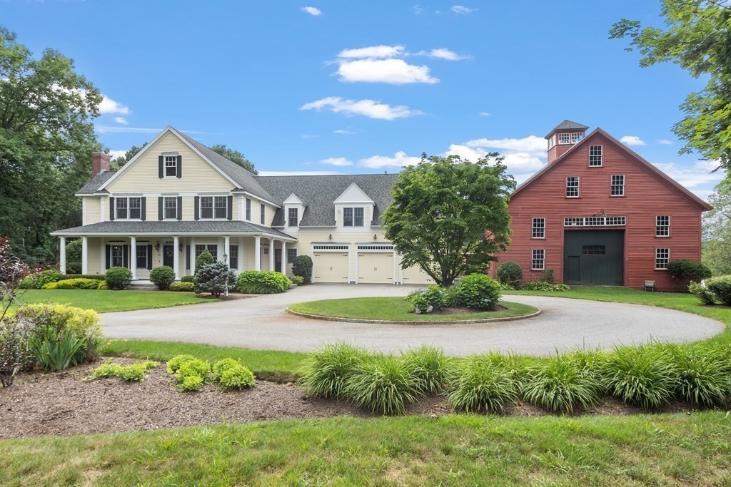 a front view of a house with a garden and trees