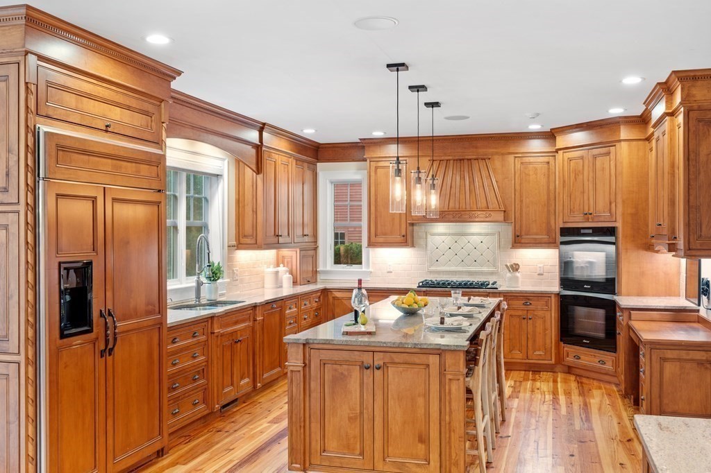 95 Westford Road Concord, MA 01742 - Photo 8 of 42 a kitchen with stainless steel appliances granite countertop a stove top oven a sink dishwasher a dining table and chairs with wooden floor