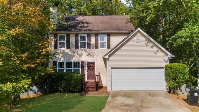 a view of a white house next to a yard