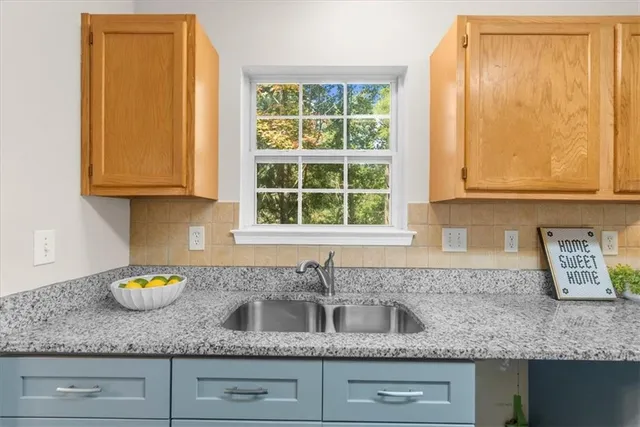 a kitchen with granite countertop cabinets sink and window