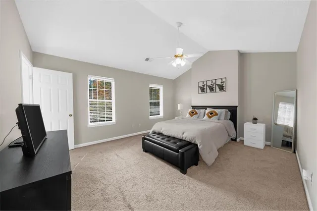 a spacious bedroom with a bed a couch and a desk in it