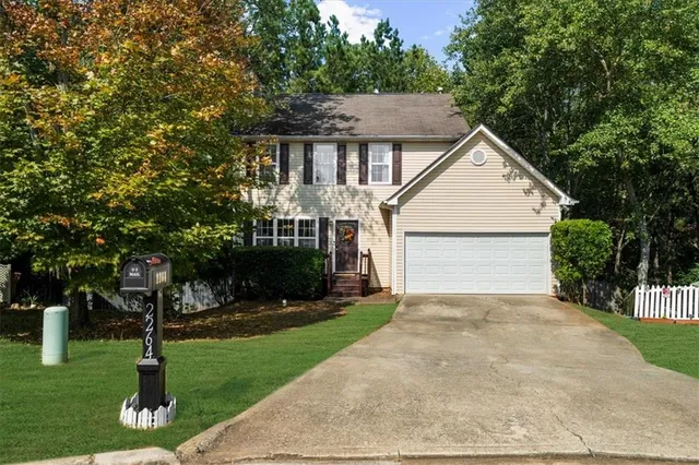 a front view of a house with a yard and trees