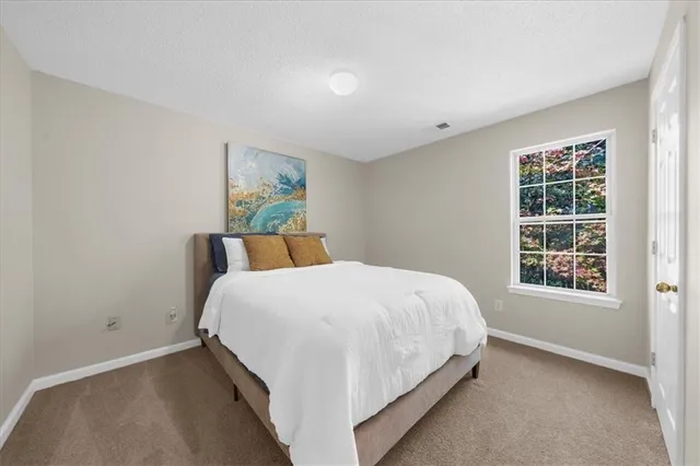 a large bed sitting in a bedroom next to a window