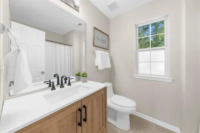 a bathroom with a sink a toilet and a window