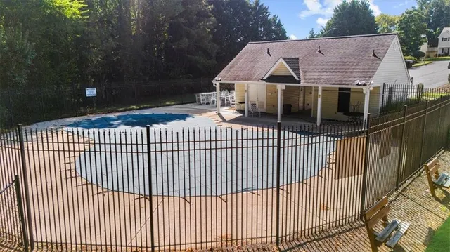 an aerial view of a swimming pool with a yard and plants