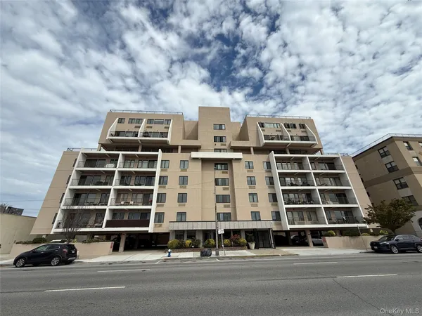 a front view of a building with car parked
