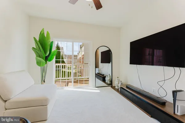 a living room with furniture a flat screen tv and a potted plant