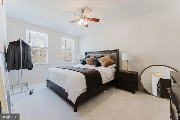 a bedroom with a bed a flat screen tv and a large window