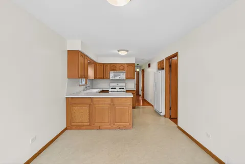 a large kitchen with stainless steel appliances granite countertop a sink and a refrigerator