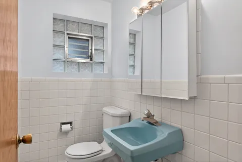 a bathroom with a sink toilet and mirror