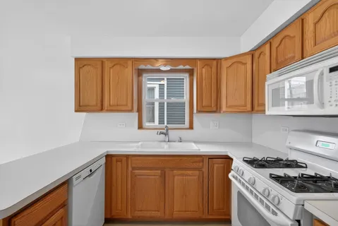a kitchen with granite countertop cabinets stainless steel appliances a sink and a window