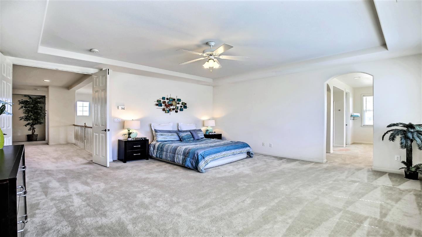 1447 Atlantic Avenue Ripon, CA 95366 - Photo 18 of 25 a spacious bedroom with a bed and a chandelier