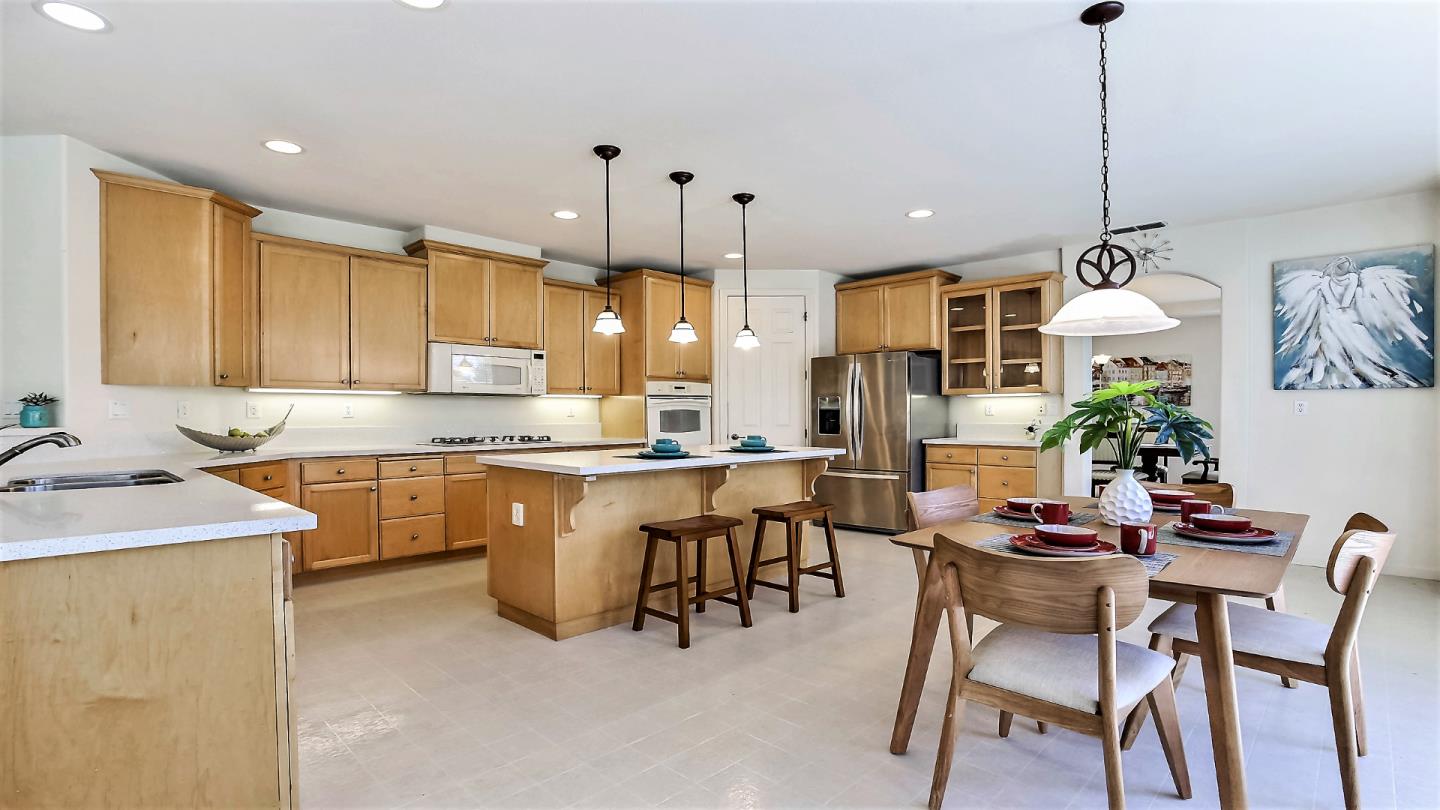 1447 Atlantic Avenue Ripon, CA 95366 - Photo 8 of 25 a kitchen with kitchen island a sink table and chairs