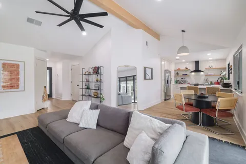 a living room with furniture and a ceiling fan