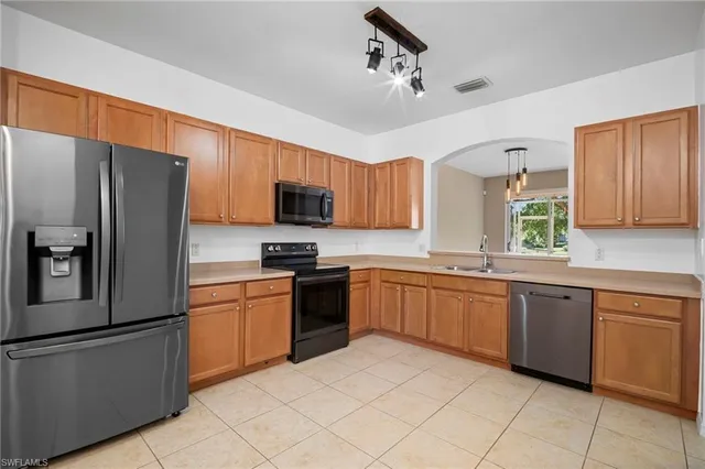 a kitchen with granite countertop stainless steel appliances cabinets and a sink