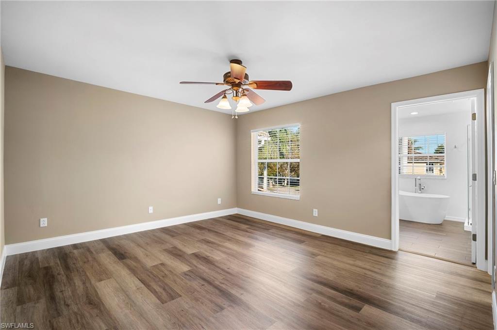 20000 Heatherstone Way, Unit 2 Estero, FL 33928 - Photo 5 of 20 an empty room with wooden floor and chandelier fan