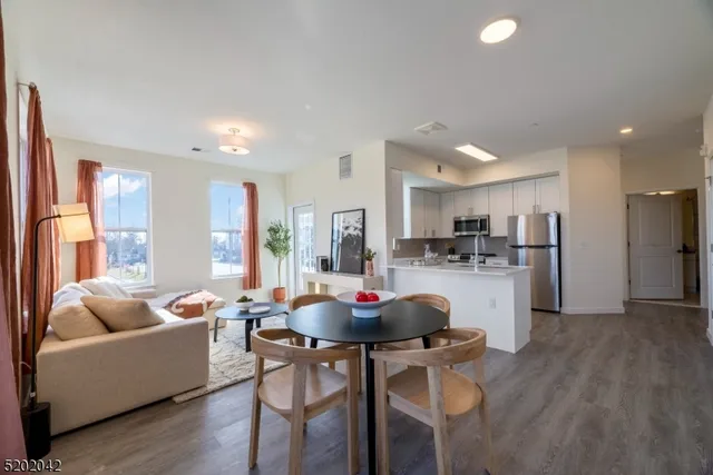 a living room with kitchen island furniture and a view of kitchen