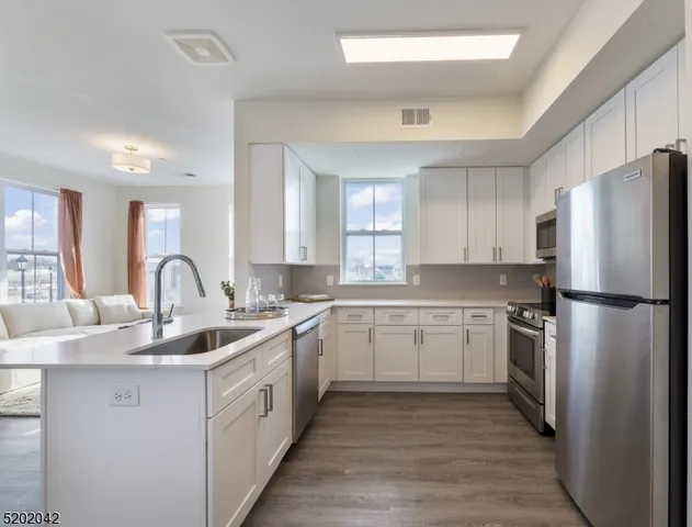 a kitchen with a white cabinets stove and white stainless steel appliances