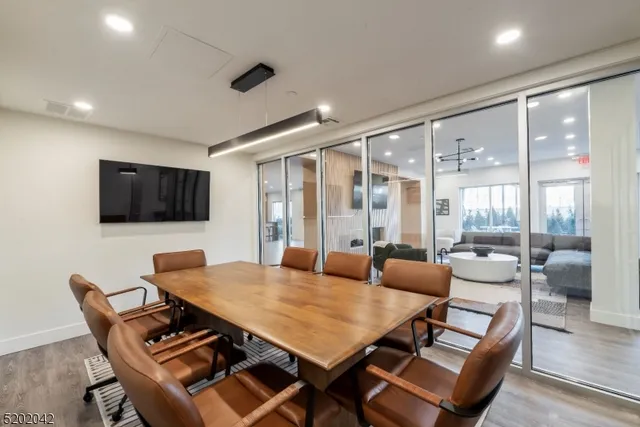 a living room with furniture a flat screen tv and a large window