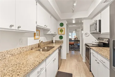 a kitchen with granite countertop a sink stove and cabinets