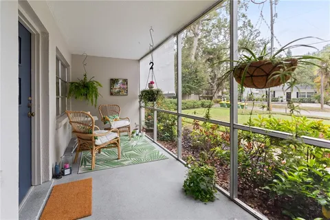 a balcony with chairs and with potted plants
