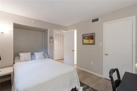 a bedroom with a bed and dresser with mirror