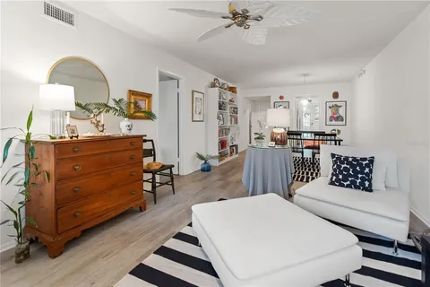 a living room with furniture and paintings on the wall