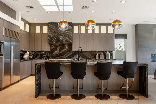 a kitchen with a dining table chairs and a wooden floor