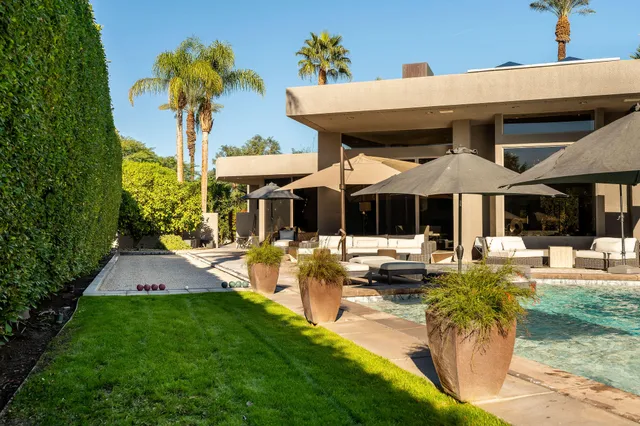 a view of a house with swimming pool and chairs