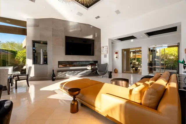 a living room with furniture flat screen tv and a large window