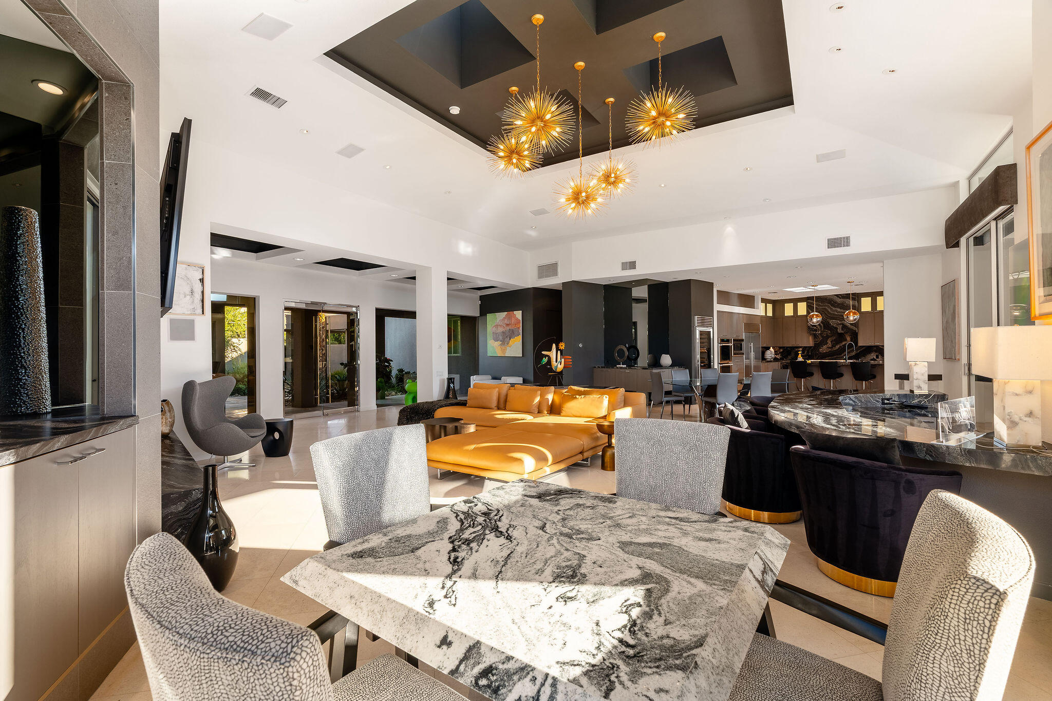 108 Waterford Circle Rancho Mirage, CA 92270 - Photo 6 of 41 a dining hall with couches a flat tv screen and a dining table with garden view