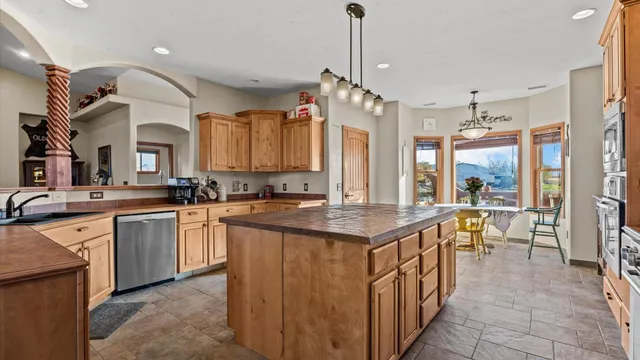 a kitchen with stainless steel appliances granite countertop a sink a stove and a refrigerator