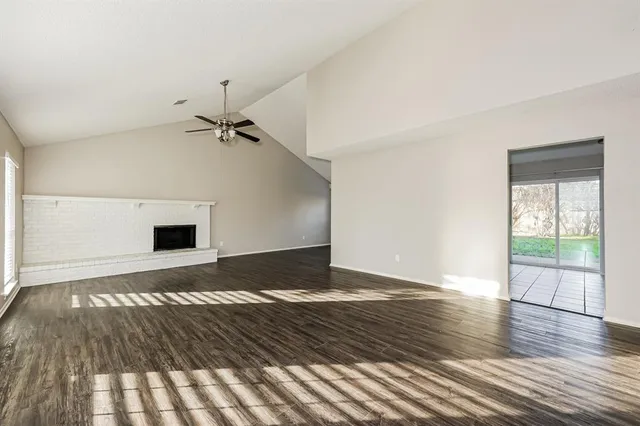a view of a livingroom with wooden floor and a ceiling fan