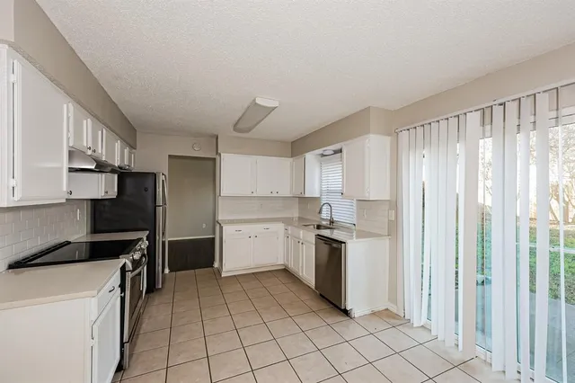 a kitchen with a stove top oven and cabinets