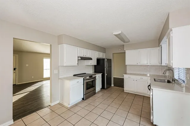 a kitchen with a stove top oven and cabinets