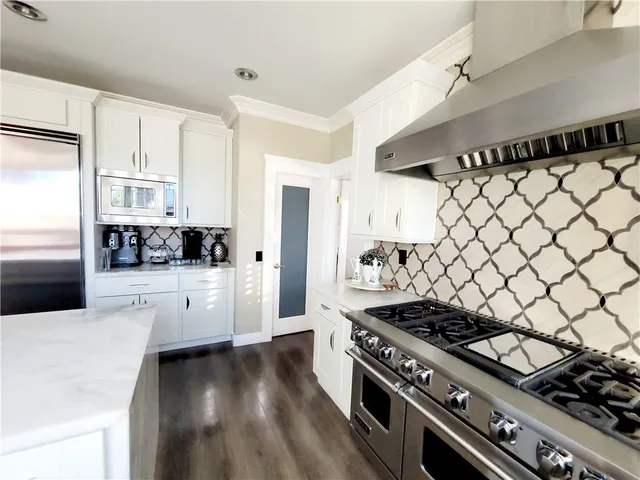 a kitchen with a stove and white cabinets