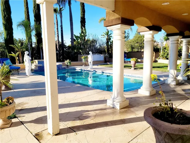 a swimming pool with yard outdoor seating and floor to ceiling window