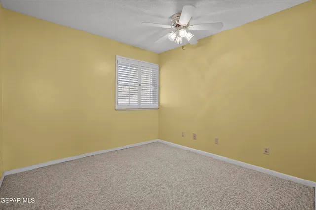 a view of empty room with ceiling fan
