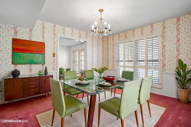 a dining room with stainless steel appliances a dining table wooden floor and a large window