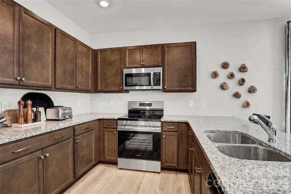a kitchen with stainless steel appliances granite countertop a sink stove and refrigerator
