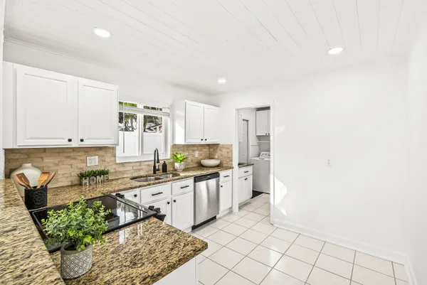 a kitchen with stainless steel appliances granite countertop a sink and a stove