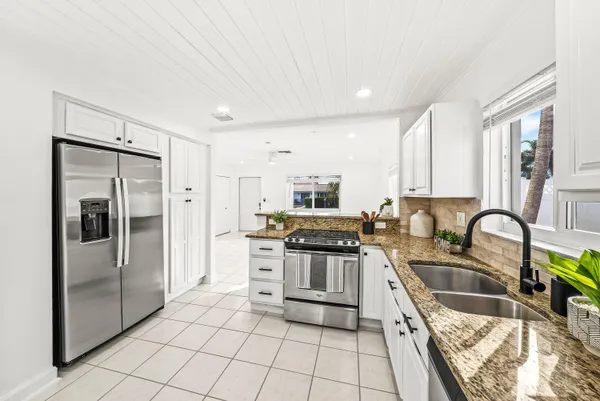 a kitchen with stainless steel appliances granite countertop a sink stove and refrigerator