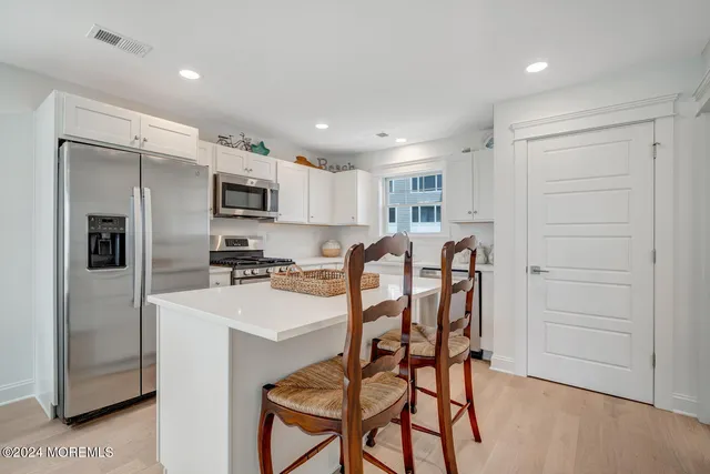 a view of a kitchen with sink a stove and wooden floor