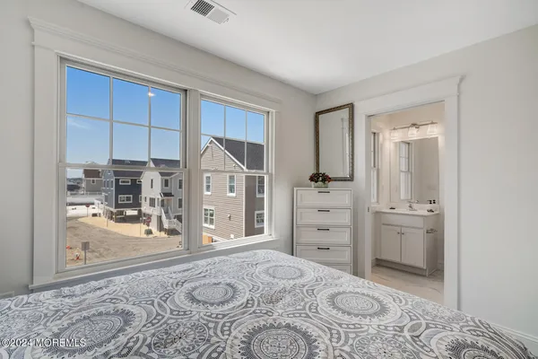 a bathroom with a toilet a sink a mirror a vanity and shower